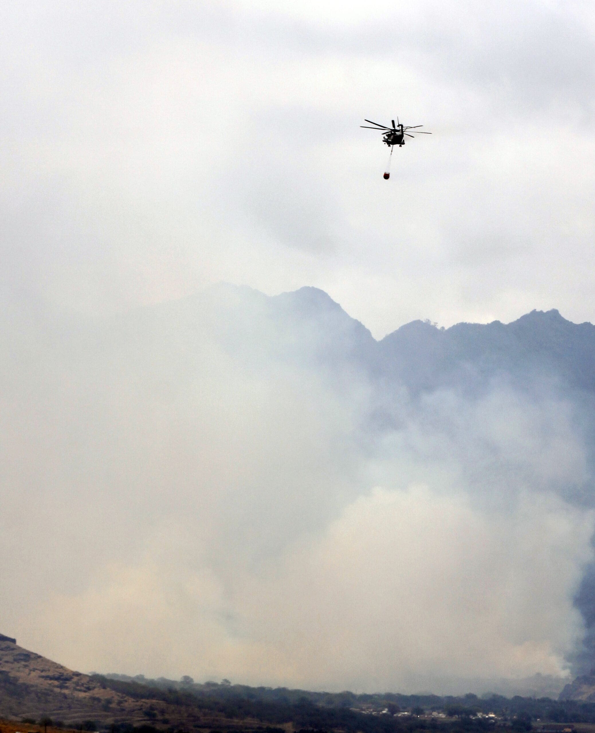 Helicopter with thimble of saltwater - putting out a wildfire Waianae